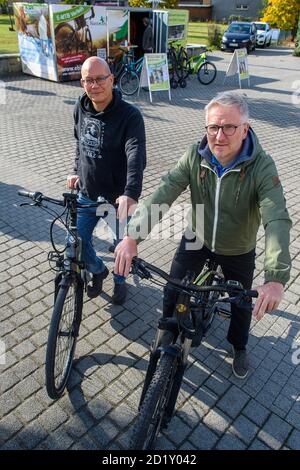 Wernigerode, Deutschland. Oktober 2020. Alexander Waturandang (l.) und Mario Wermuth vom Fahrradladen 'Harzmobil' sitzen vor ihrer Verleihbox auf E-Bikes, die sie dort mieten. Die temporäre Box steht seit Anfang September auf dem Platz in der Nähe des Bahnhofs. Bis Ende Oktober können Touristen, die am Bahnhof ankommen, elektrische Stadtfahrräder, E-Mountainbikes oder elektronische Motorroller mieten. Quelle: Klaus-Dietmar Gabbert/dpa-Zentralbild/ZB/dpa/Alamy Live News Stockfoto