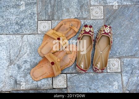 Zwei Paar Mojari Schuhe oder Mojadis Lederpantoffeln auf grauem Fliesenhintergrund. Obere Winkelansicht Stockfoto