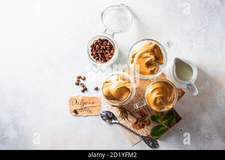 Iced schaumig Getränk Dalgona Kaffee, Trend koreanische Getränk Latte Espresso mit Kaffee. Grauer Betonhintergrund. Stockfoto