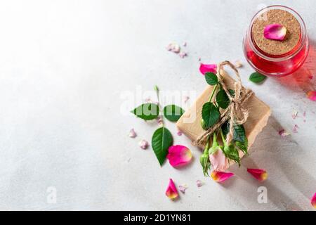 Bio handgemachte Seife, rosa Rose Knospe auf weißem Beton Hintergrund. Natürliche und nicht abfallende kosmetische Inhaltsstoffe. Gesundes Lifestyle-Konzept. Stockfoto