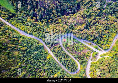 Winding Road umgeben von bunten Bäumen im Wald. Luftdrohnenansicht. Kesselberg Stockfoto
