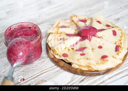 Hausgemachte französische Pfannkuchen, serviert mit Brombeereis im Glas auf weißem Holztisch. Seitenansicht . Hochwertige Fotos Stockfoto