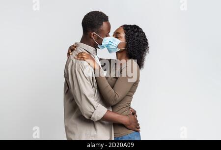 Schwarzes Paar Küssen Sich Gegenseitig In Schützende Medizinische Masken Stockfoto