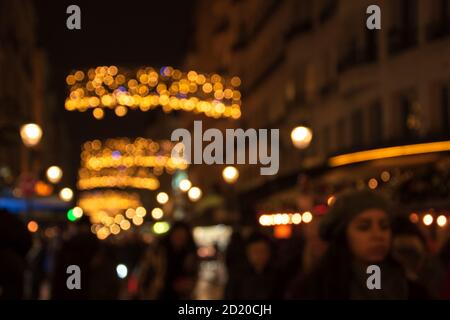 Verschwommenes Foto der Montorgueil Straße in Paris bei Nacht mit schönen Weihnachtslichtern Dekoration und unkenntlich Menge. Winterurlaub Urlaub an Stockfoto