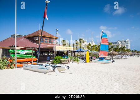 Karibik, Niederländische Antillen, Aruba, Palmenstrand, Aruba Wassersportcenter mit Hotel Riu Palace in der Ferne Stockfoto