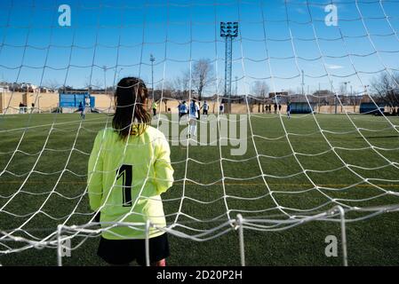 Torhüterin steht auf dem Tor. Nicht erkennbare weibliche Fußballspieler spielen ein Spiel auf dem Fußballplatz. Jugend weibliche Fußballmannschaft spielt Tourna Stockfoto