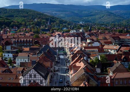 Wernigerode, Deutschland. Oktober 2020. Die hellen Fassaden der Fachwerkhäuser und die roten Dächer der Stadt zeichnen sich durch den verblassenden und bläuenden Wald an den Hängen des Harzes aus. Es ist Herbst geworden und die Sonne ist schon um die schon deutlich niedriger als im Sommer, der erst vor wenigen Wochen zum Herbst wurde. In den kommenden Tagen wird erwartet, dass sich der Himmel immer wieder öffnet und die Sonne herauskommt. Alles in allem bleibt es aber eine harte Mischung aus Sonne, Wolken, Schauern und Wind. Quelle: Klaus-Dietmar Gabbert/dpa-Zentralbild/ZB/dpa/Alamy Live News Stockfoto