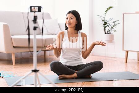 Sportliche asiatische Frau Dreharbeiten Übungen für Heimtraining Stockfoto