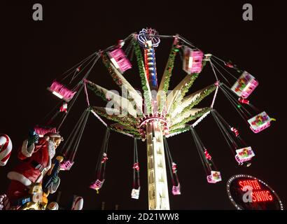 PARIS, FRANKREICH - 6. JANUAR 2019: Weihnachtsmann schaukelt auf dem Weihnachtsmarkt in Paris. Festlich, voller Freude City Nachtleben während der Winterferien. Stockfoto