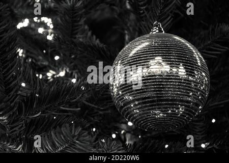 Glänzend gestreifte Weihnachtskugeln auf Weihnachtsbaum und Weihnachtslichter Girlande. Weihnachten Hintergrund. Winterurlaub Konzept. Reflexion. Bokeh. Selektiv f Stockfoto