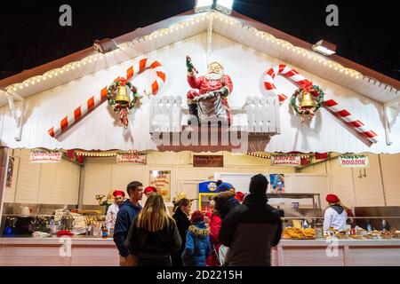 PARIS, FRANKREICH - 6. JANUAR 2019: Leute mit Kindern kaufen traditionelle frische Waffeln und Crepes, heiße Schokolade, Glühwein usw. auf dem Weihnachtsmarkt Stockfoto