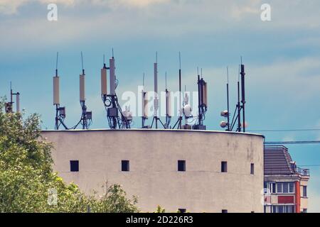 Antennen und 5g Mobilfunk-Basisstationen auf dem Dach von Das Gebäude Stockfoto