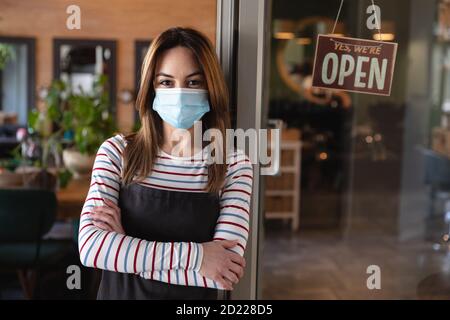 Portrait von weiblichen Friseur lehnt sich an die Glastür an Friseursalon Stockfoto