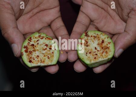 Guava-Früchte in Menschenhand mit Salz und kaltem Pulver schneiden. Stockfoto