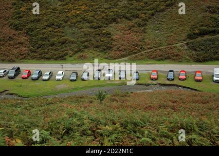 Reihe von Autos geparkt in der Carding Mill Valley, Shropshire, England, Großbritannien. Stockfoto