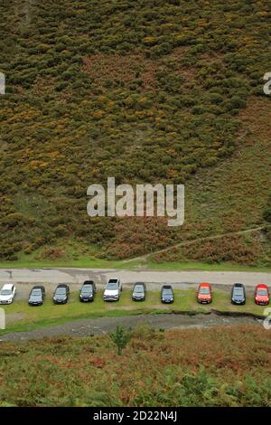 Reihe von Autos geparkt in der Carding Mill Valley, Shropshire, England, Großbritannien. Stockfoto