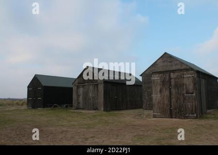 Landschaft von alten Holzfischen Winterton Norfolk East Anglia großbritannien Strand auf Sandgras in der Nähe der Küste mit blauem Himmel Weiße Wolke auf hellen kalten Winter Stockfoto