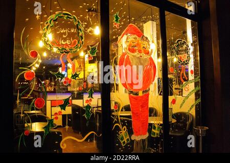 PARIS, FRANKREICH - 18. DEZEMBER 2016: Pariser Cafeteria-Fenster mit Weihnachtsmann und fröhlichem Weihnachtskranz geschmückt ('Joyeux Noël' auf Französisch) Stockfoto