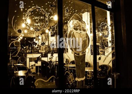 PARIS, FRANKREICH - 18. DEZEMBER 2016: Pariser Cafeteria-Fenster mit Weihnachtsmann und fröhlichem Weihnachtskranz geschmückt ('Joyeux Noël' auf Französisch) Stockfoto