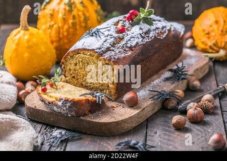 Leckerer Kürbiskuchen auf Schneidebrett. Laib Brot mit Kürbissen. Halloween-Essen Stockfoto