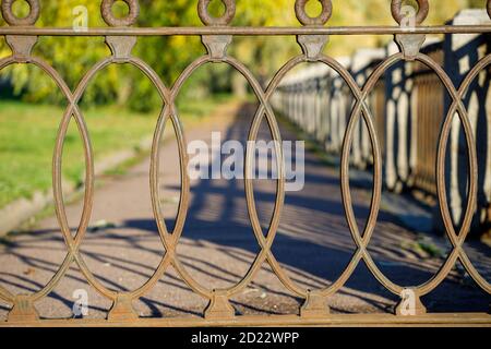 Schönes schmiedeeisernes Gitter im Park im Herbst Stockfoto