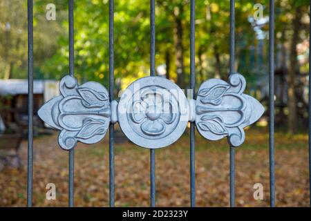 Schönes schmiedeeisernes Gitter im Park im Herbst Stockfoto