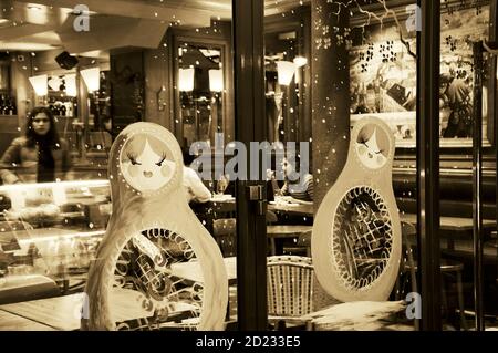 PARIS, FRANKREICH - 27. DEZEMBER 2015: Pariser Café Vitrine zu Weihnachten mit matryoshka Puppen und Schneeflocken dekoriert. Sepia historisches Foto Stockfoto