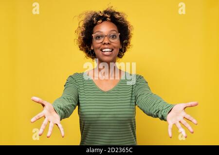 Junge afroamerikanische Frau lächelt mit offenen Armen für Umarmung Ihre Freunde willkommen heißen Stockfoto