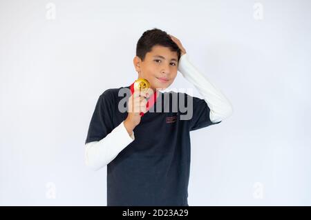 Glücklicher kleiner Junge mit goldener Medaille auf weißem Hintergrund Stockfoto