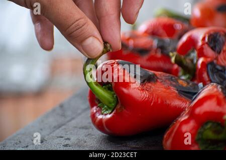 Rote Paprika rösten auf einem Holzofen in Vorbereitung für die Herstellung ajvar, ein traditionelles serbisches Gericht Stockfoto