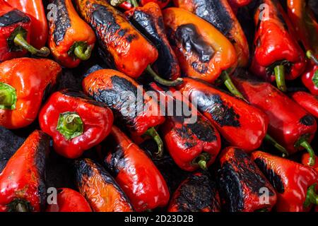 Rote Paprika rösten auf einem Holzofen in Vorbereitung für die Herstellung ajvar, ein traditionelles serbisches Gericht Stockfoto