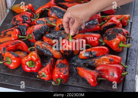 Rote Paprika rösten auf einem Holzofen in Vorbereitung für die Herstellung ajvar, ein traditionelles serbisches Gericht Stockfoto