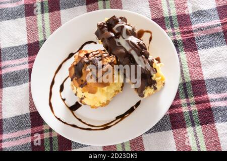 Cream Pie. Zwei Schichten aus Blätterteig mit Schlagsahne mit geschmolzener Schokolade auf einem weißen Teller dekoriert gefüllt Stockfoto