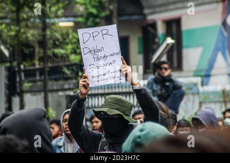 Bandung, Indonesien. Oktober 2020. Ein Protestler hält während des Protestes ein Plakat, das seine Meinung vor dem Parlamentsbüro ausdrückt. Studenten protestierten gegen den Omnibus-Gesetzentwurf der Regierung zur Schaffung von Arbeitsplätzen, der das Wirtschaftswachstum ankurbeln und Arbeitsplätze schaffen sollte, was ihrer Meinung nach die Arbeitnehmer ihrer Rechte berauben und die Umwelt in Indonesien untergraben würde. Kredit: SOPA Images Limited/Alamy Live Nachrichten Stockfoto