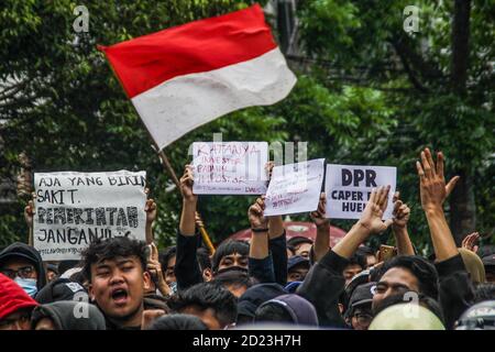 Bandung, Indonesien. Oktober 2020. Während des Protestes halten Demonstranten Plakate, die ihre Meinung vor dem Parlamentsbüro ausdrücken. Studenten protestierten gegen den Omnibus-Gesetzentwurf der Regierung zur Schaffung von Arbeitsplätzen, der das Wirtschaftswachstum ankurbeln und Arbeitsplätze schaffen sollte, was ihrer Meinung nach die Arbeitnehmer ihrer Rechte berauben und die Umwelt in Indonesien untergraben würde. Kredit: SOPA Images Limited/Alamy Live Nachrichten Stockfoto