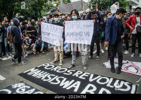 Bandung, Indonesien. Oktober 2020. Während des Protestes halten Demonstranten Plakate, die ihre Meinung vor dem Parlamentsbüro ausdrücken. Studenten protestierten gegen den Omnibus-Gesetzentwurf der Regierung zur Schaffung von Arbeitsplätzen, der das Wirtschaftswachstum ankurbeln und Arbeitsplätze schaffen sollte, was ihrer Meinung nach die Arbeitnehmer ihrer Rechte berauben und die Umwelt in Indonesien untergraben würde. Kredit: SOPA Images Limited/Alamy Live Nachrichten Stockfoto