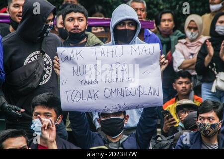 Bandung, Indonesien. Oktober 2020. Ein Protestler hält während des Protestes ein Plakat, das seine Meinung vor dem Parlamentsbüro ausdrückt. Studenten protestierten gegen den Omnibus-Gesetzentwurf der Regierung zur Schaffung von Arbeitsplätzen, der das Wirtschaftswachstum ankurbeln und Arbeitsplätze schaffen sollte, was ihrer Meinung nach die Arbeitnehmer ihrer Rechte berauben und die Umwelt in Indonesien untergraben würde. Kredit: SOPA Images Limited/Alamy Live Nachrichten Stockfoto