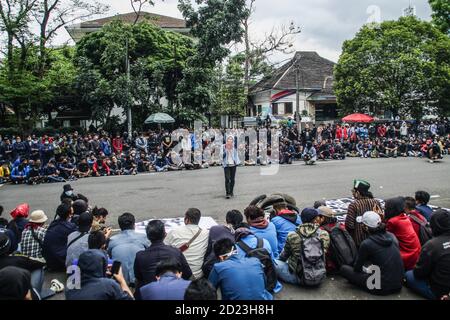 Bandung, Indonesien. Oktober 2020. Ein Protestler spricht während des Protestes mit einem Megaphon vor einer Menschenmenge außerhalb des Parlamentsbüros. Studenten protestierten gegen den Omnibus-Gesetzentwurf der Regierung zur Schaffung von Arbeitsplätzen, der das Wirtschaftswachstum ankurbeln und Arbeitsplätze schaffen sollte, was ihrer Meinung nach die Arbeitnehmer ihrer Rechte berauben und die Umwelt in Indonesien untergraben würde. Kredit: SOPA Images Limited/Alamy Live Nachrichten Stockfoto