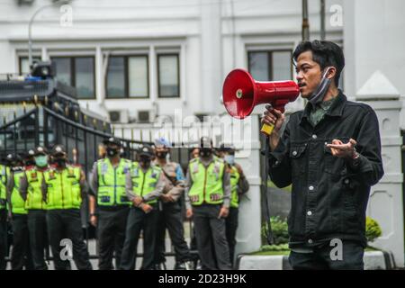Bandung, Indonesien. Oktober 2020. Ein Protestler spricht während des Protestes durch ein Megaphon vor dem Parlamentsbüro. Studenten protestierten gegen den Omnibus-Gesetzentwurf der Regierung zur Schaffung von Arbeitsplätzen, der das Wirtschaftswachstum ankurbeln und Arbeitsplätze schaffen sollte, was ihrer Meinung nach die Arbeitnehmer ihrer Rechte berauben und die Umwelt in Indonesien untergraben würde. Kredit: SOPA Images Limited/Alamy Live Nachrichten Stockfoto