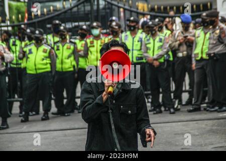Bandung, Indonesien. Oktober 2020. Ein Protestler spricht während des Protestes durch ein Megaphon vor dem Parlamentsbüro. Studenten protestierten gegen den Omnibus-Gesetzentwurf der Regierung zur Schaffung von Arbeitsplätzen, der das Wirtschaftswachstum ankurbeln und Arbeitsplätze schaffen sollte, was ihrer Meinung nach die Arbeitnehmer ihrer Rechte berauben und die Umwelt in Indonesien untergraben würde. Kredit: SOPA Images Limited/Alamy Live Nachrichten Stockfoto