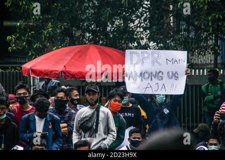 Bandung, Indonesien. Oktober 2020. Ein Protestler hält während des Protestes ein Plakat, das seine Meinung vor dem Parlamentsbüro ausdrückt. Studenten protestierten gegen den Omnibus-Gesetzentwurf der Regierung zur Schaffung von Arbeitsplätzen, der das Wirtschaftswachstum ankurbeln und Arbeitsplätze schaffen sollte, was ihrer Meinung nach die Arbeitnehmer ihrer Rechte berauben und die Umwelt in Indonesien untergraben würde. Kredit: SOPA Images Limited/Alamy Live Nachrichten Stockfoto