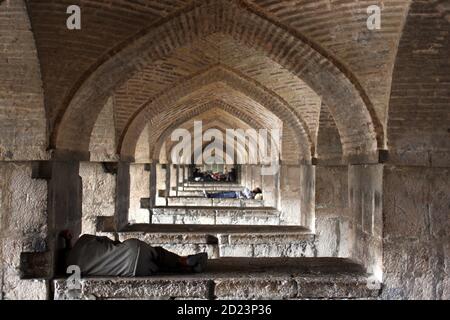 Schlafen unter den Bögen der Si-oh-eh-Brücke, Isfahan, Islamische Republik Iran Stockfoto