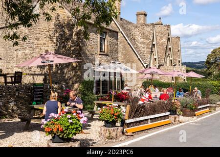 Sozial distanzierte Kunden im Haus Carpenters Arms an einem sonnigen Tag während der Covid 19 Restriktionen im Cotswold Dorf Miserden, Glos Stockfoto