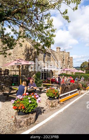 Sozial distanzierte Kunden im Haus Carpenters Arms an einem sonnigen Tag während der Covid 19 Restriktionen im Cotswold Dorf Miserden, Glos Stockfoto