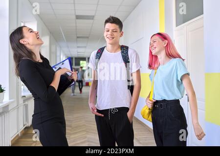 Gruppe von Jugendlichen Studenten im Gespräch mit einer Lehrerin in Schulflur Stockfoto