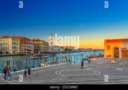 Venedig, Italien, 13. September 2019: Fondamenta Salute Uferpromenade in der Nähe der Pier des Grand Canal Wasserstraße bei Sonnenuntergang, Campanile Glockenturm und Reihe von barocken Gebäuden in San Marco Sestiere Stockfoto