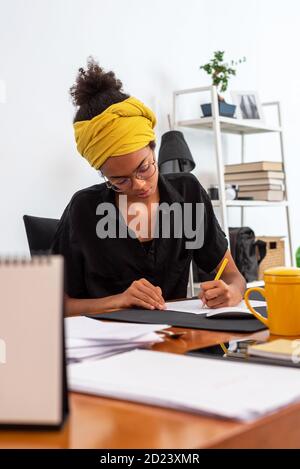 Aufnahme einer jungen lateinischen Frau, die im Heimbüro arbeitet Stockfoto