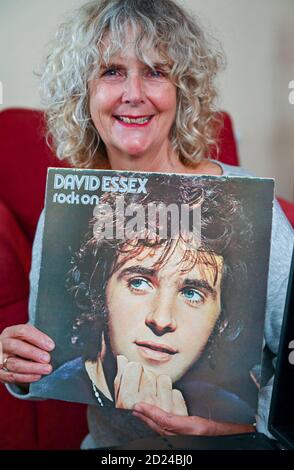 Frau mittleren Alters mit einer alten Kopie von David Essex LP-Album Rock On, herausgegeben 1973 von Columbia Records Stockfoto