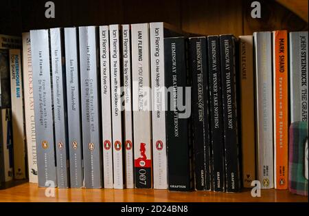 James Bond Spionage Romane geschrieben von Autor Ian Fleming und Ernest Hemingway Bücher im Bücherregal zu Hause Stockfoto