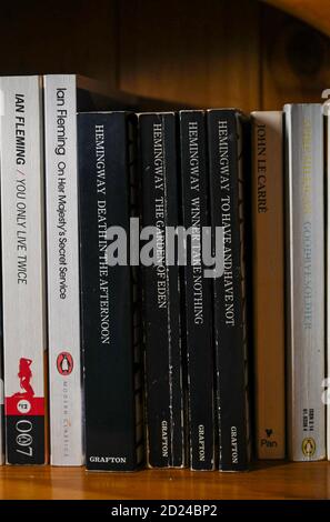 James Bond Spionage Romane geschrieben von Autor Ian Fleming und Ernest Hemingway Bücher im Bücherregal zu Hause Stockfoto